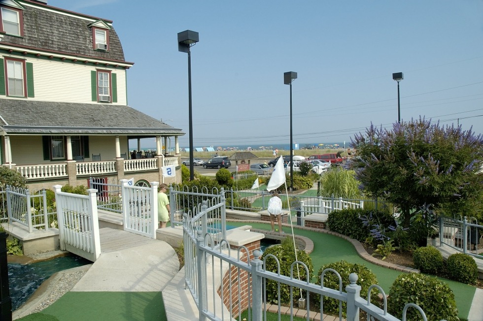 Miniature golf course with the white clubhouse on the elft