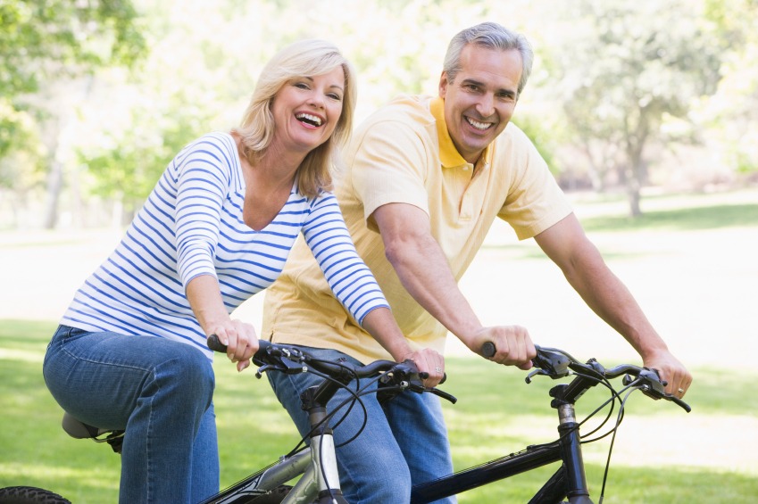 A man and a woman on bikes smiling at the camera
