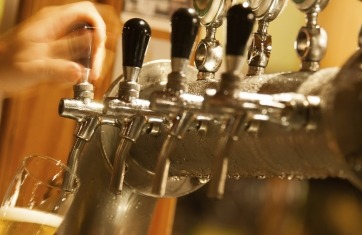 closeup of beer taps with a person pouring a beer into a glass