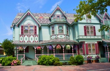 Exterior of victorian home that is green with maroon accents